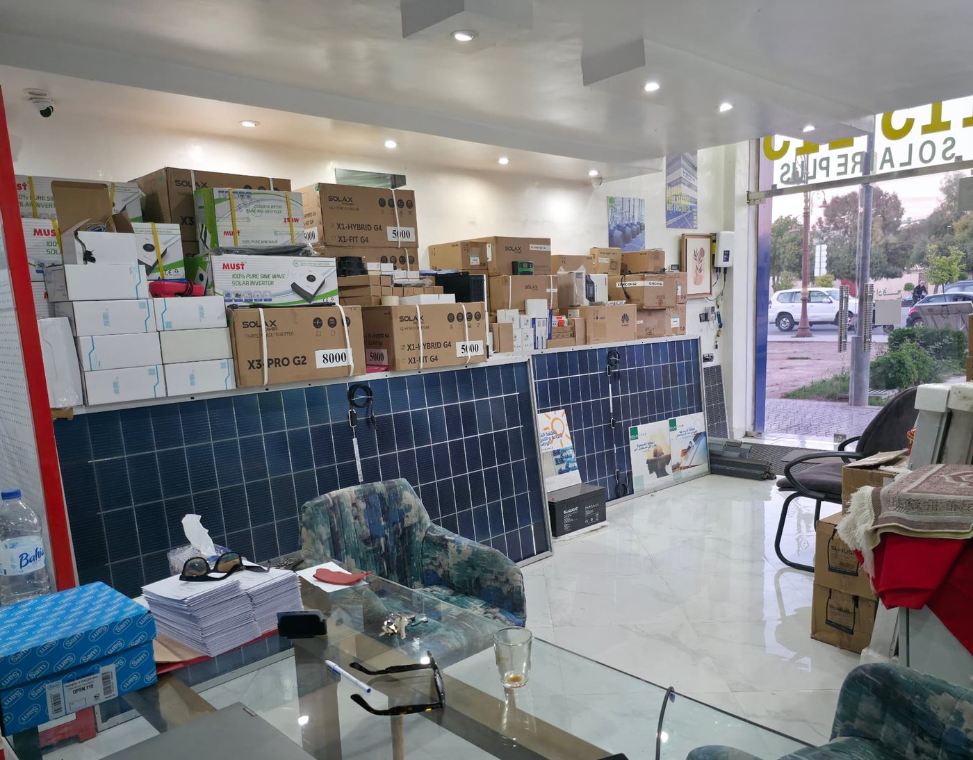 Intérieur du showroom SOLAIRE PLUS avec panneaux, batteries et coffrets électriques